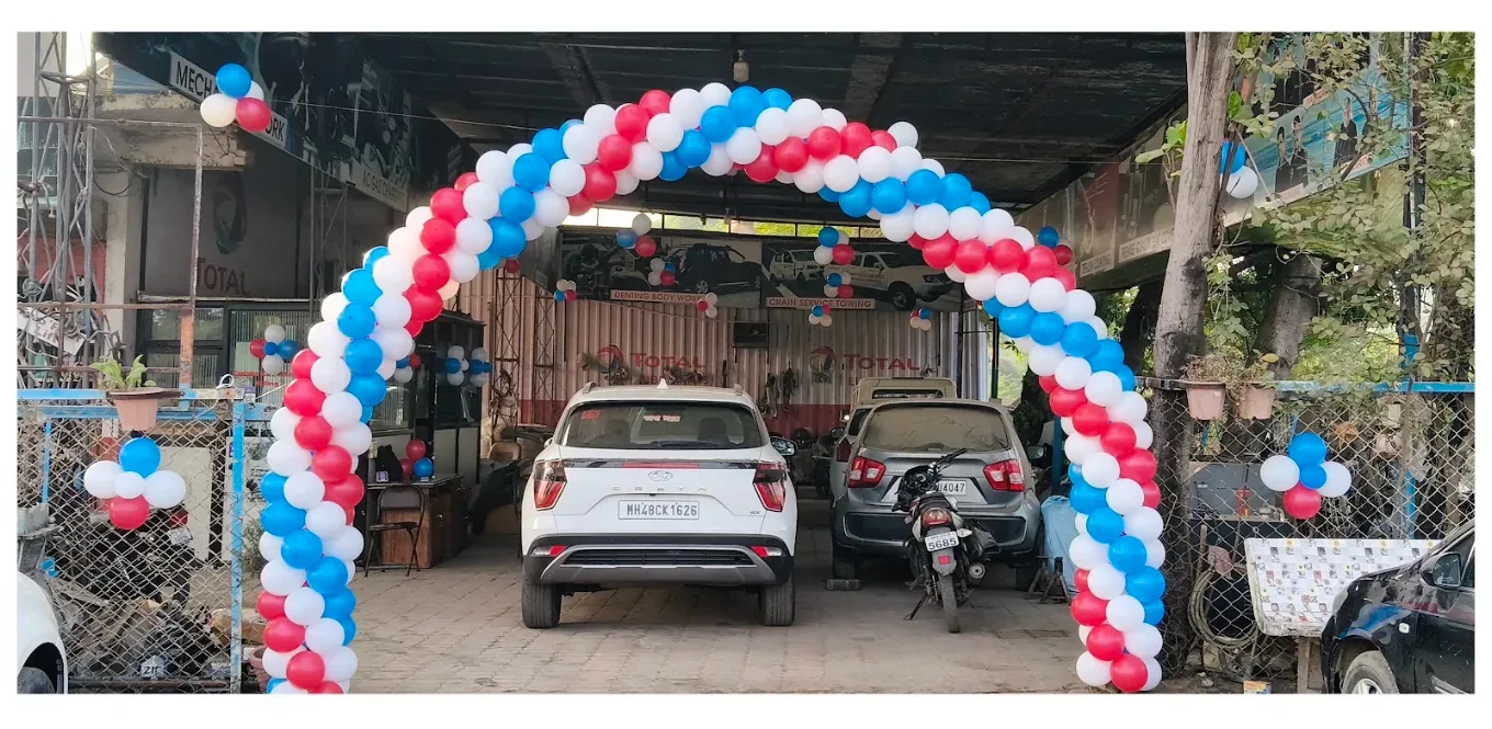 Cars parked under the decorated arch at Sanju Maruti Services
